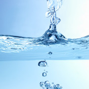 A drop of water plunges into a body of water, creating a ripple effect --- Image by © Royalty-Free/Corbis